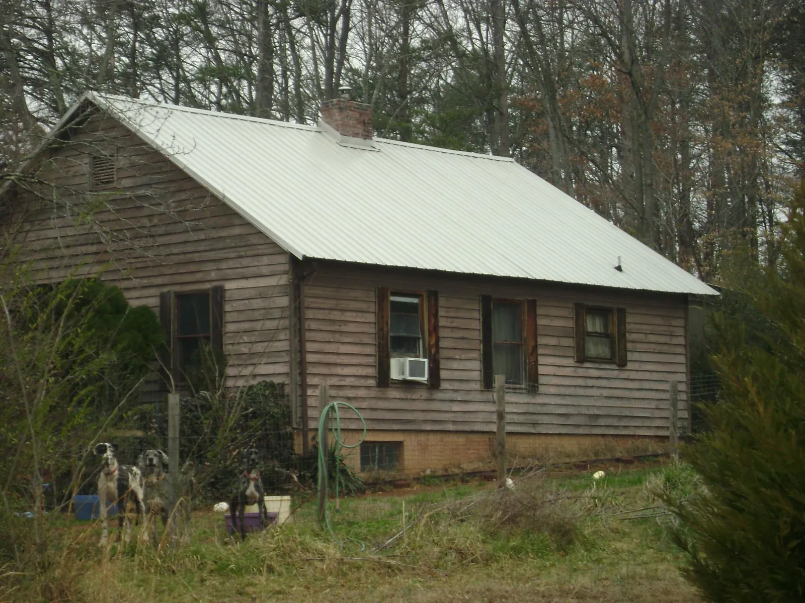White metal roof on an old wood sided farmhouse, from a Metal Roof Installation job in Conrad